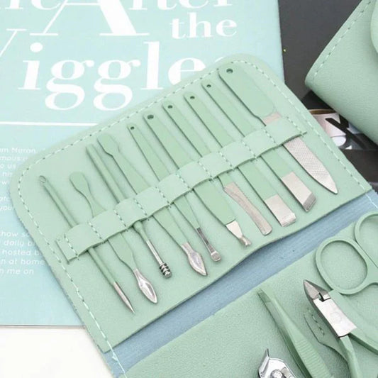 Mint green professional manicure kit with stainless steel grooming tools displayed on a magazine background, including nail clippers, scissors, cuticle tools, tweezers, and nail care accessories.