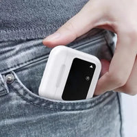 Person placing a small white electronic device into a pocket, demonstrating its compact, lightweight, and portable design for convenient everyday carrying and use.