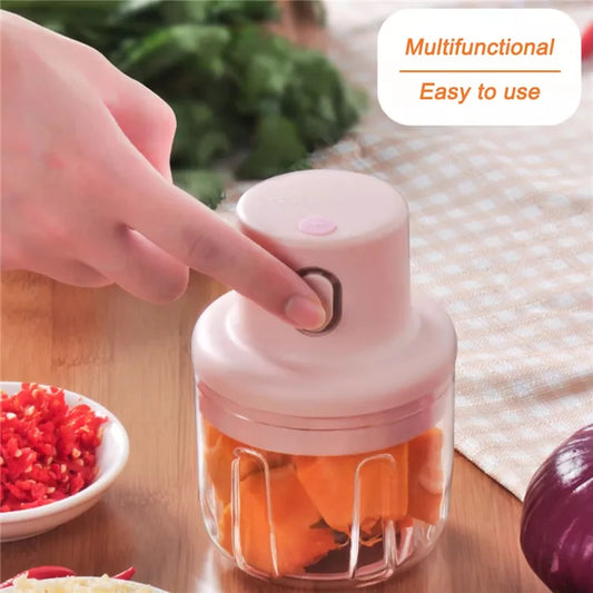 Handheld food chopper with fresh vegetables on a kitchen counter, multifunctional design for quick and easy chopping, slicing, and food preparation.