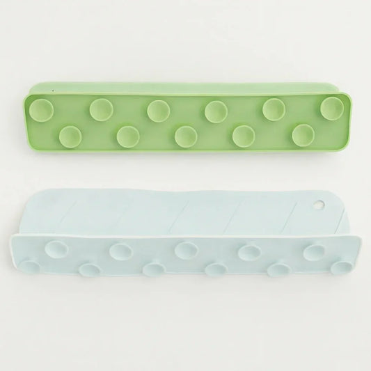 Two green and light blue rectangular sink splash guard mats with textured circular patterns on a white background, designed to reduce water splashes and protect kitchen countertops.