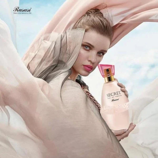 Woman holding a pink Secret perfume bottle against a blurred sky background, showcasing an elegant women's fragrance with a stylish design and a fresh, feminine appeal.
